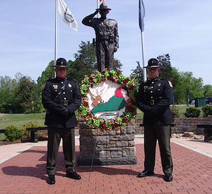Two Fish and Wildlife officers standing in front of memorial